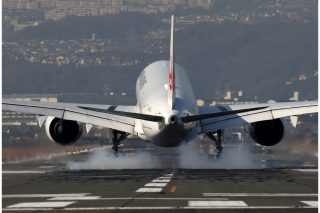 旅客機が着陸した瞬間に煙があがる。
